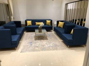 طقم كنب أزرق كحلي كامل بأرجل ذهبية وطاولة مرايا في صالة بالرياض